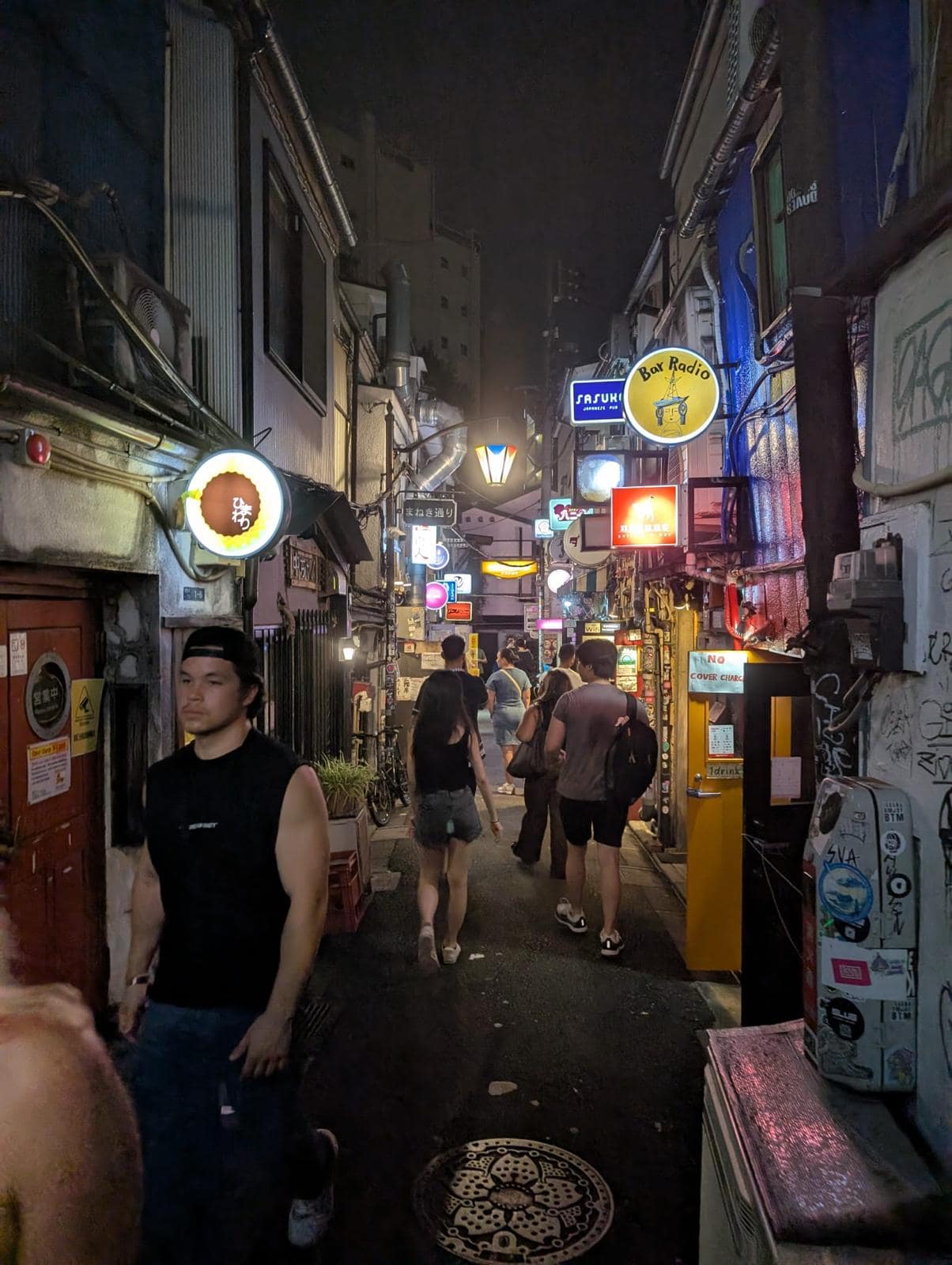 Night street in Tokyo with bright signs and crowds, showing a vibrant but potentially overwhelming sensory environment