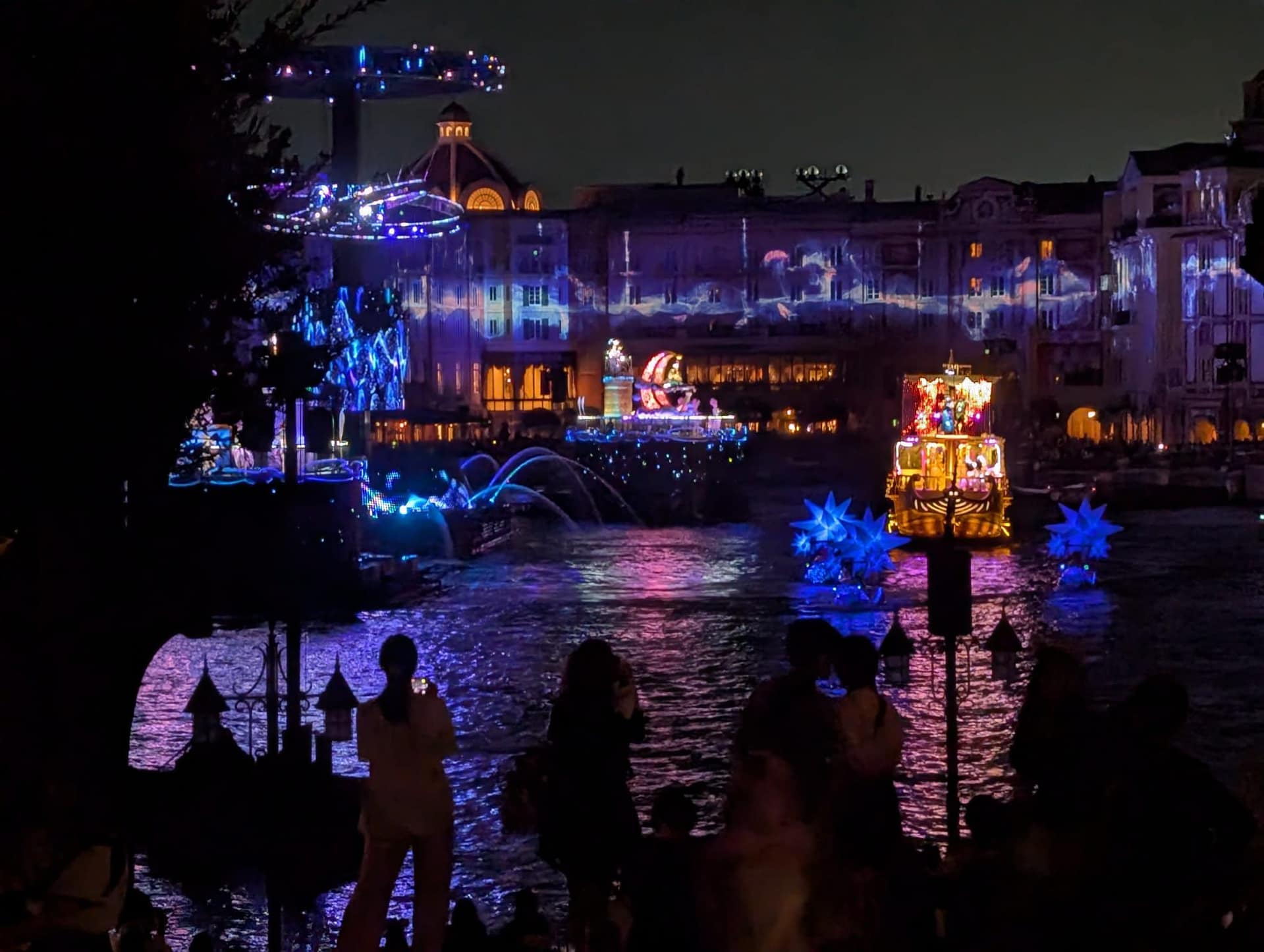 Tokyo DisneySea at night with colourful lights reflecting on water
