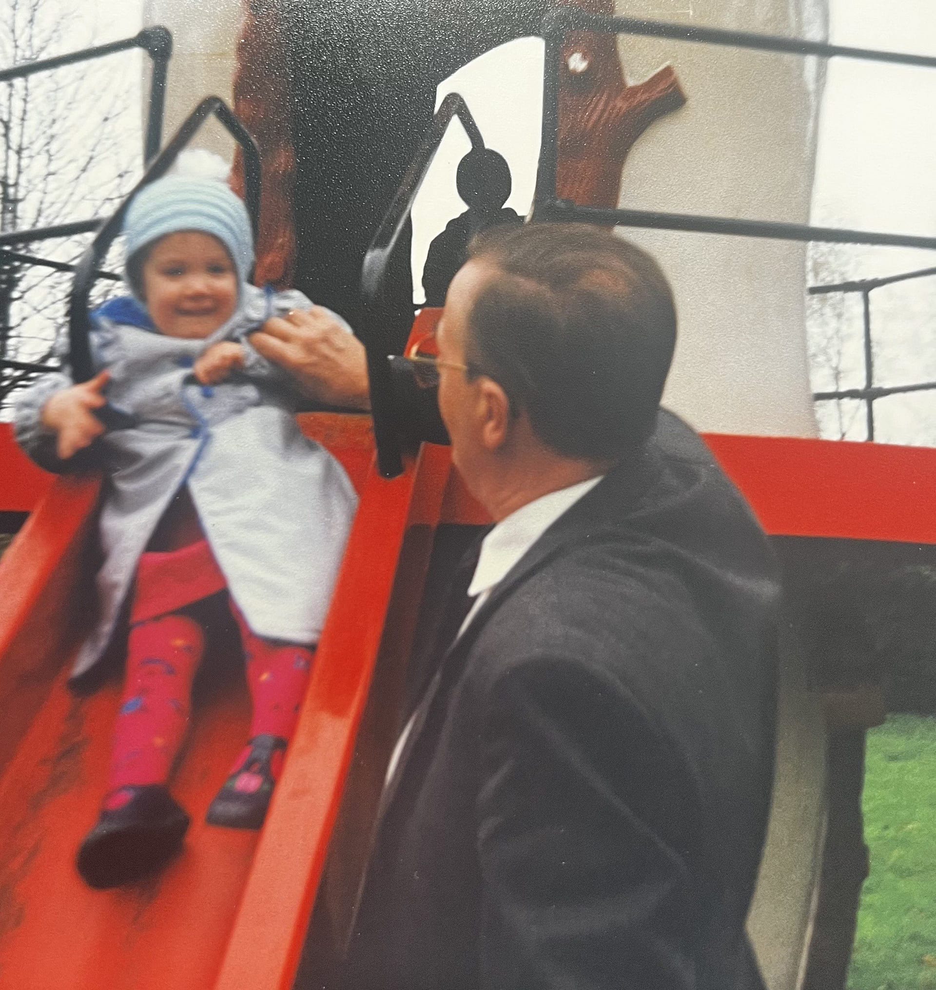 Childhood photo of me and my grandad playing on a slide together.